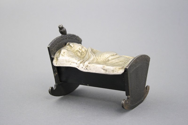Baby in Cradle: American - Circa 1897 A sweet little bird watches over junior while he sleeps. Material: Cast Iron and Sheet Tin Provenance: Ralph Dye Collection
