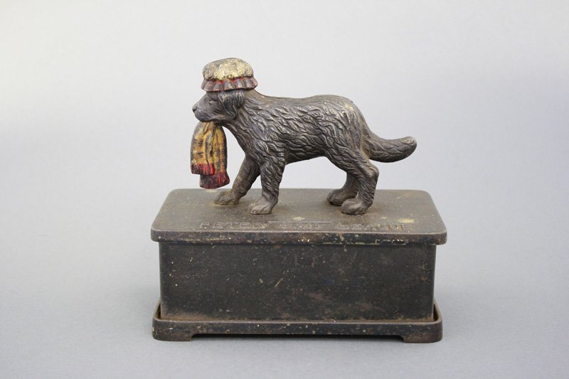 Peter Pan League Alms Box: English - Circa 1910 - 6.75” L The story of Peter Pan was written by J. M. Barrie of Scotland in 1904. This bank depicts Wendy’s dog “Nana”. It is inscribed, “Peter Pan League” and appears