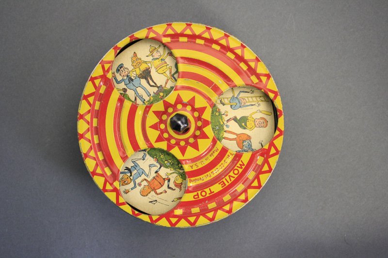 Palmer Cox Brownie “Movie Top”: American - Dated 1927 - 4.5” W This spinning top when turned, optically creates a movie about Palmer Cox’s famed Brownies. A wonderful optical toy. Material: Tin and Paper