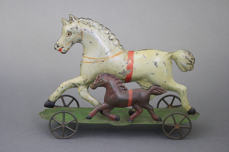 Horse and Colt on Platform: George Brown- - Connecticut - Circa 1885 - 8.5” L This colorful platform toy depicts a mare out trotting with its young colt. Material: Tin