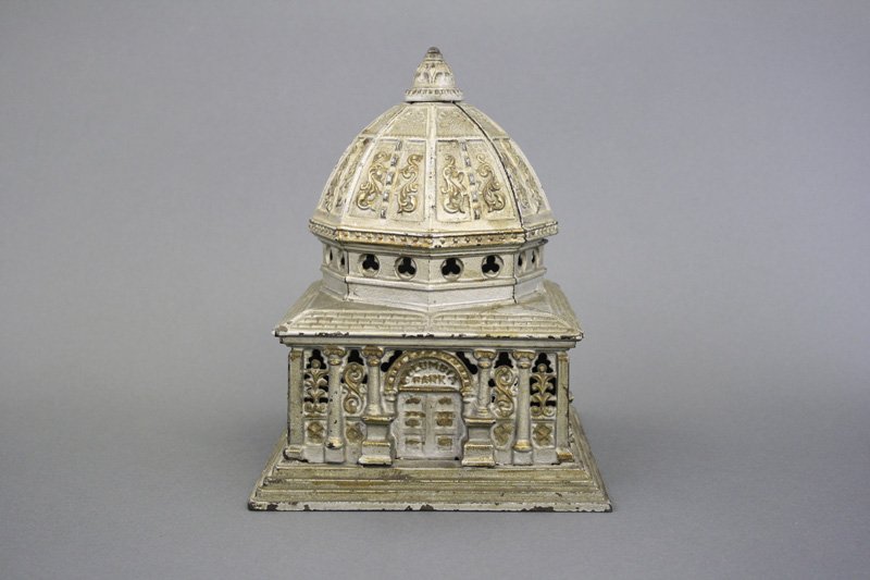 Columbia Bank - Largest Size: Kenton Hardware Kenton, Ohio - Circa 1893 - 8.75” H The grand-daddy of Columbia banks. This one is super, all original, silver paint with gold highlights. It retains its original trap. Material: Cas
