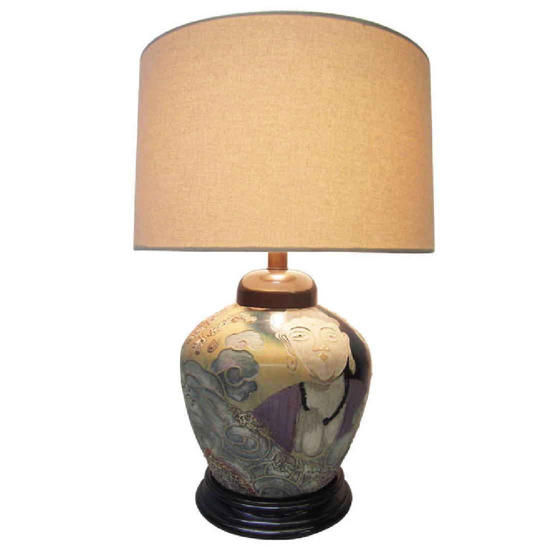 Asian-Influence Lamp by Frederick Cooper: The base of this large table lamp features intricate Asian artwork depicting two faces separated by waves. The embossed and glazed design is vibrant and detailed. The beige linen shade has a 17? diame
