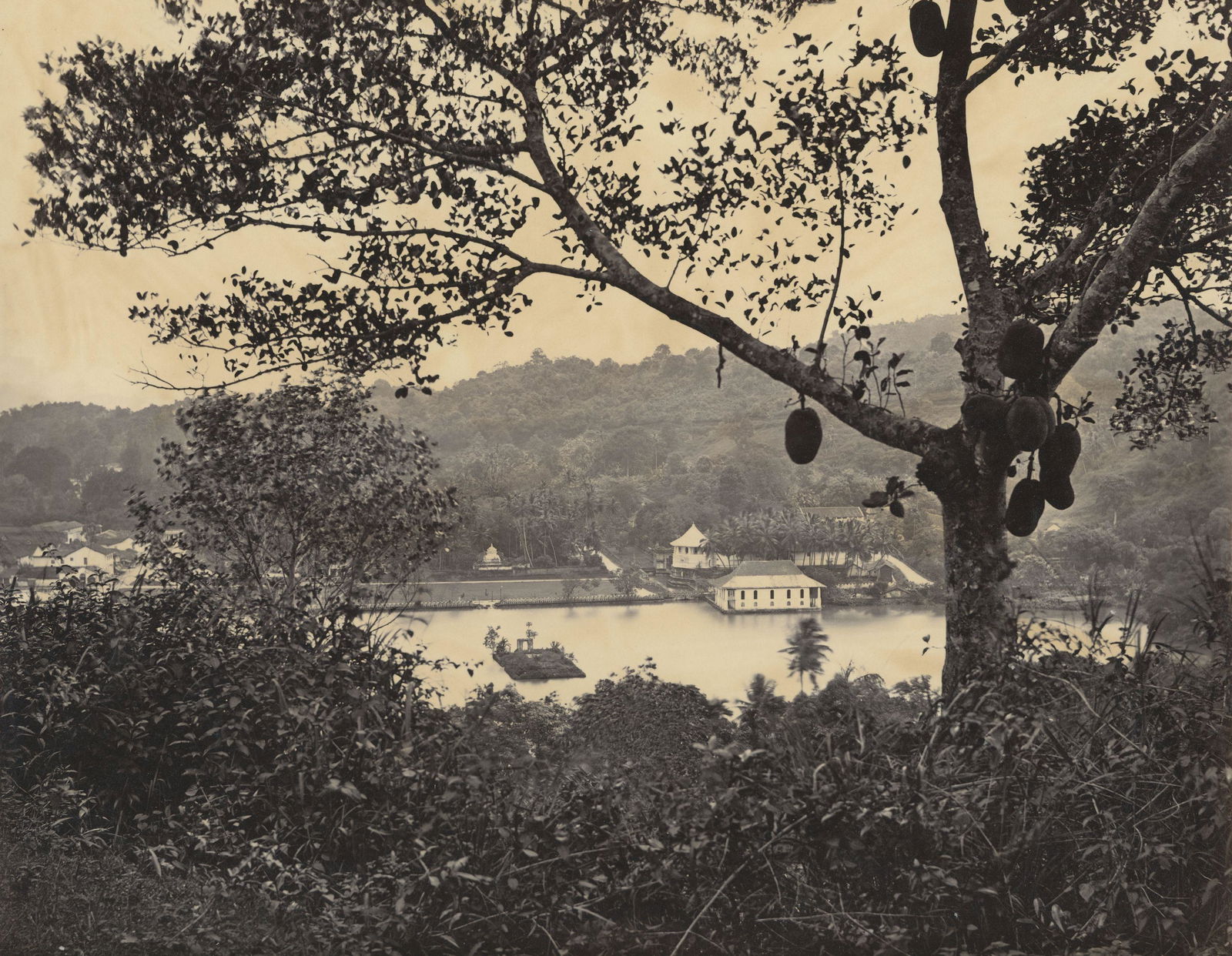 Kandy; a peep from the Upper Lake Road, showing the: Kandy; a peep from the Upper Lake Road, showing the Temple and Island. Samuel Bourne #2134. Bourne photographs of Ceylon are rare. Excellent contrast and tonality. 8.75 x 10.875 in.