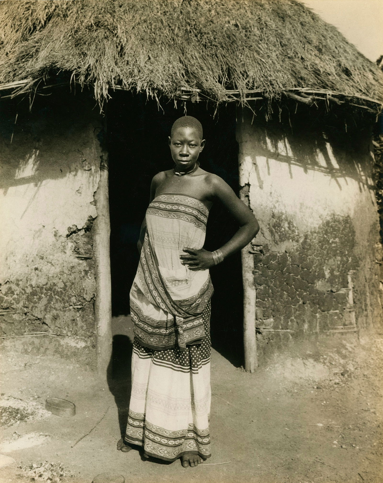 Uganda Lady outside her Hut. c1925: Uganda Lady outside her Hut. c1925. By Ewing Galloway Agency. Very good contrast and tonality. 9.5 x 7.5 in.