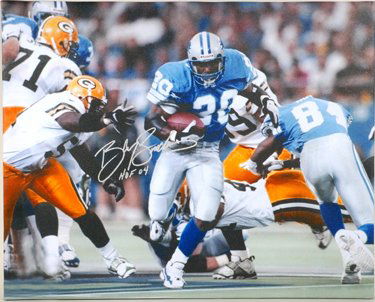 Barry Sanders Signed 30 x 24 Canvas Print B GAI: Attractive 24" x 30" color photograph on framed canvas featuring an excellent on-field portrait of Sanders evading the Green Bay defense, boldly signed and inscribed in silver metallic marker, "Barry