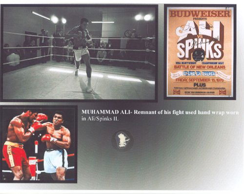 Muhammad Ali Worn Fight Relic Display: A .5" x .5" piece of Muhammad Ali's fight worn hand wrap, worn during Ali's second fight against Leon Spinks. Swatch is affixed to an 8.5 x 11 display sheet, with biographical information and a photo
