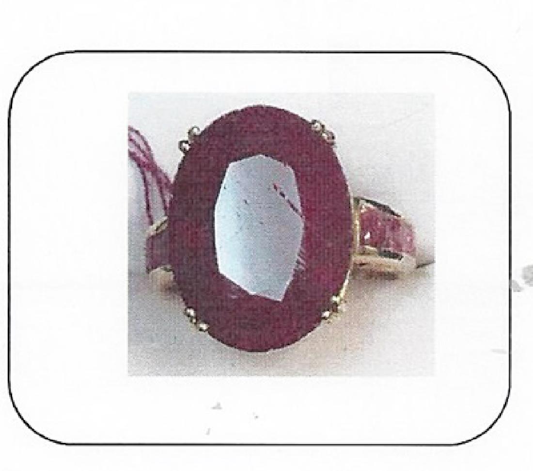 Lady's 10K yellow gold ruby ring: This lady 10K yellow gold ruby ring is comprised of 4 prongs set oval cut ruby surrounded by channel set 6 round rubies. Total weight of the rubies are 4.85ctw the total weight of the ring is 5.69gms.