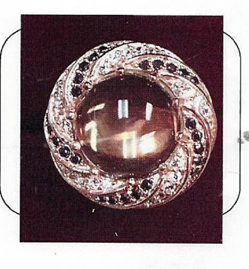 Lady's silver lemon quartz ring: This lady silver lemon quartz ring comprised of 10 prongs set round cabochon cut lemon quartz surrounded by 25 black stones and 25 round stones. Total weight of the ring is 11.45gms.