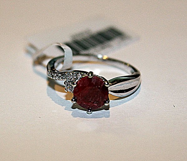 Stunning Womens Ruby & Diamond Ring: Stunning womens ruby and diamond ring set in 925 sterling silver. The round cut ruby is approximately 1.50 CT and the round cut diamonds are approximately .05CT. The ring size is 7.