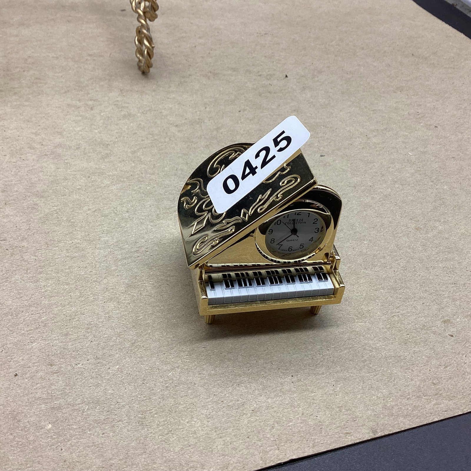 BRASS PIANO QUARTZ CLOCK BY BREEZE W/JAPAN MOVENMENT: 1" T X 2" W NEEDS BATTIERS
