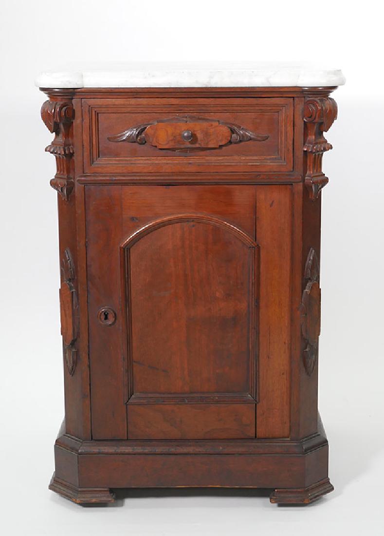 Victorian Carved Walnut Marble Top Half Commode: This solid walnut half commode is paneled on all sides, including the back side and front door. The piece features leaf and scroll carved corner supports and carved wing-shaped drawer front. The white