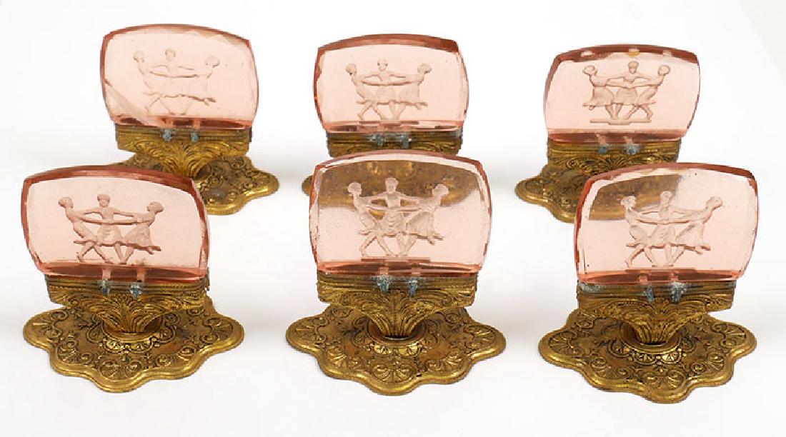 Set of 6 Pink Glass Intaglio Place Card Holders: Set of 6 intaglio cut "Three Graces" pink glass place card holders on ormolu bases. Excellent condition. Measure 1 1/2" tall.