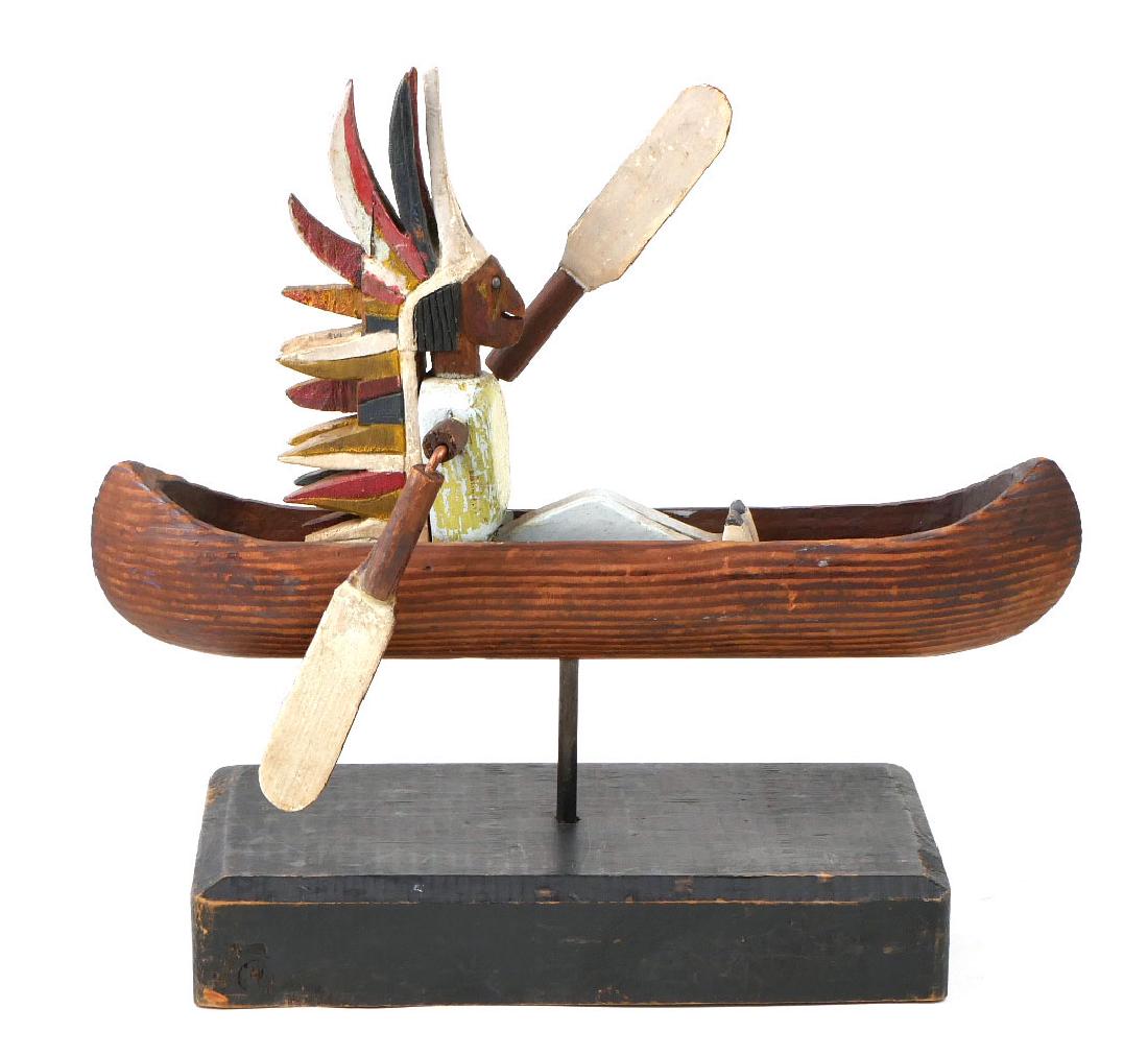 Carved Wood Indian Paddling Canoe Whirligig: Hand carved and painted wood whirligig of seated Native American paddling a canoe. Good condition, some loss to tips of a few feathers in headdress on one side. Likely dates to 1930s. Mounted on later