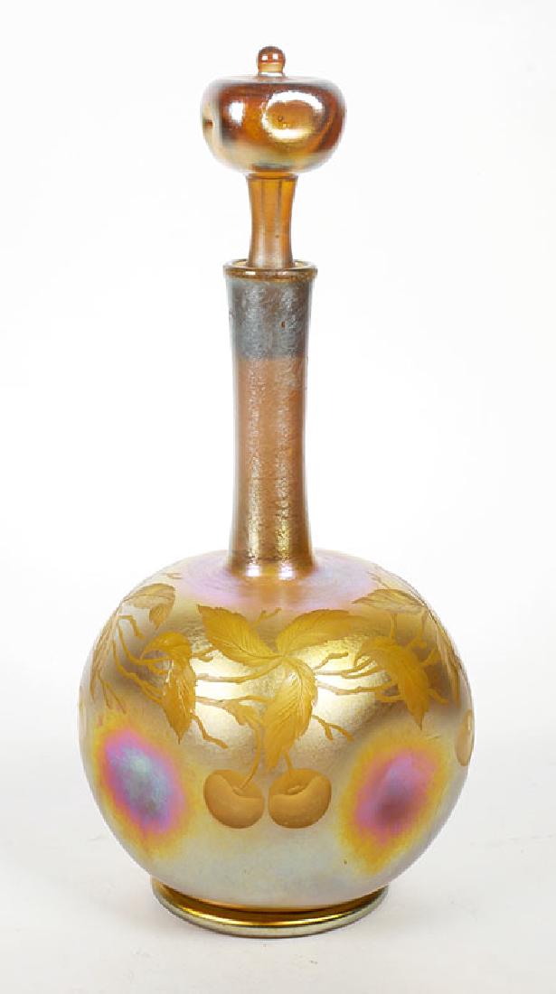 LC Tiffany Favrile Iridescent Art Glass Decanter: Authentic antique L.C. Tiffany Favrile decanter with intaglio cherries and vines design. Measures about 10-1/4" high. Pinched side panels. Stopper in excellent condition. There is a C-shaped hairline 