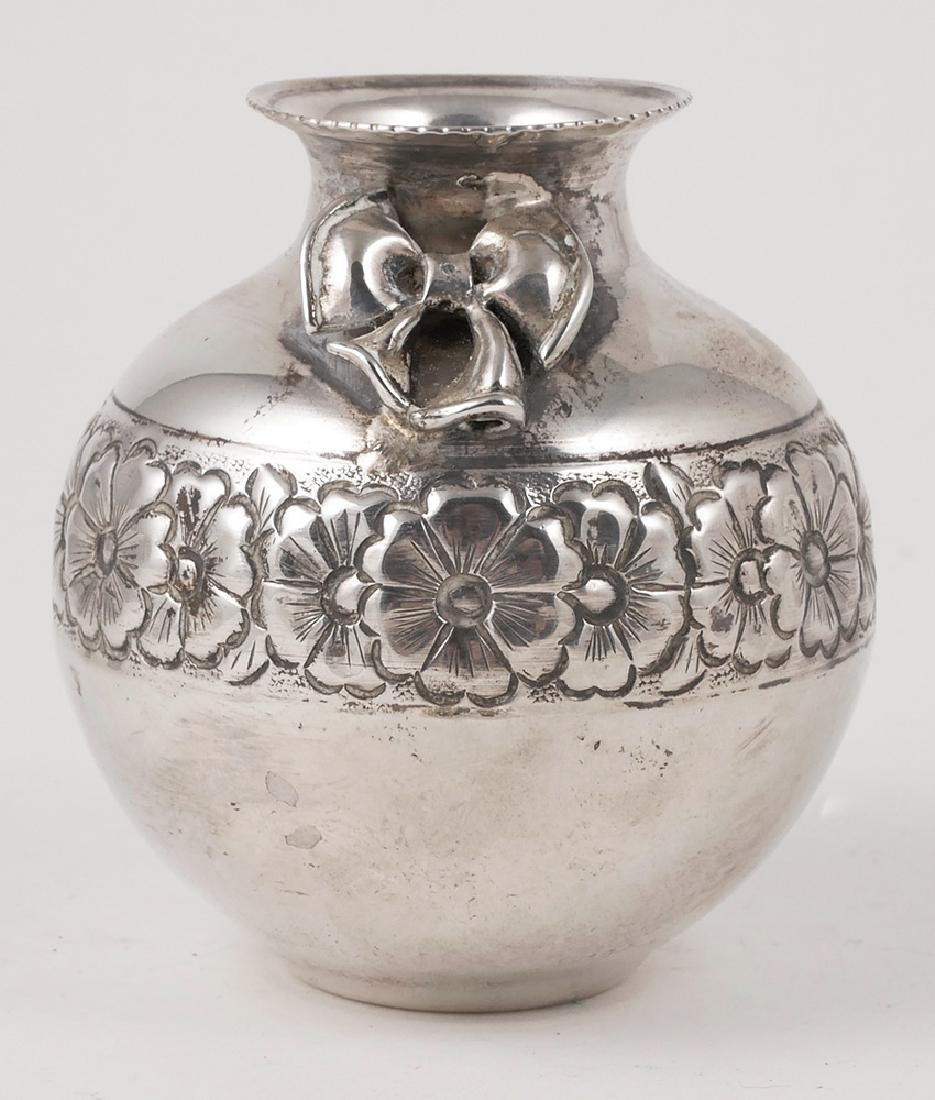 Antique 900 Coin Silver Repousse Cabinet Vase: Measures 3-1/2" high and weighs about 3.6 Troy ounces. Band of repousse flowers around belly and an applied bow on neck. Probably Turkish in origin. Marked with DA 900 hallmark on bottom.