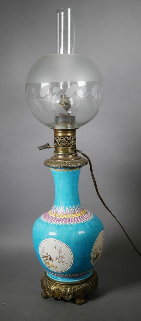 French 19th Century Faience Oil Lamp: French faience art pottery baluster form lamps, possibly Longwy or Theodore Deck, decorated with bird and floral motif, mounted with brass base and hardware. Globe and chimney included, shade partiall