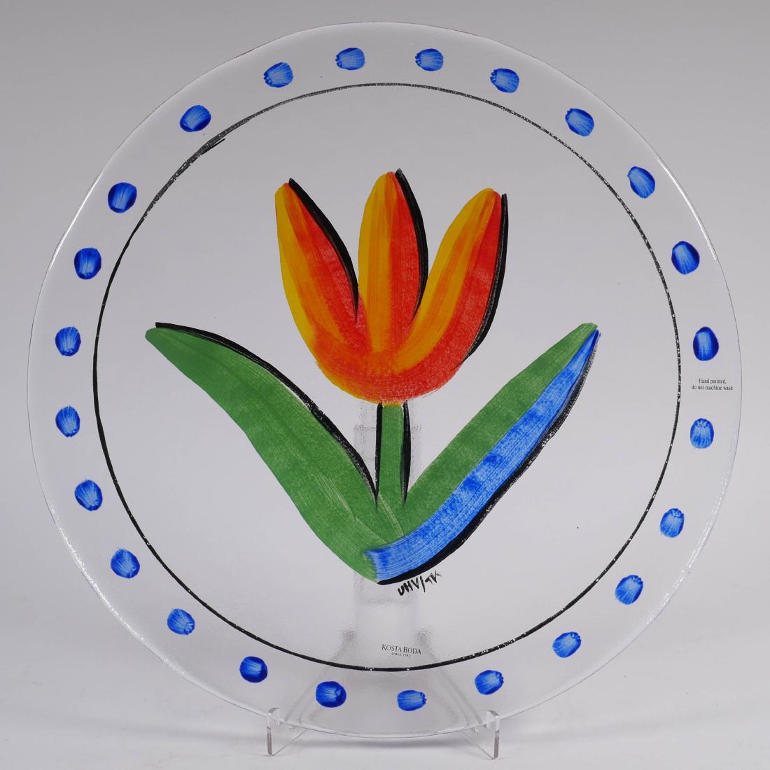 Kosta Boda Hand Painted Tulip Serving Plate: Kosta Boda reverse painted art glass tulip serving plate by artist Ulrica Hydman-Vallien. Signed lower right, retains original Kosta Boda label. Measures approx. 12-3/4" in diameter.
