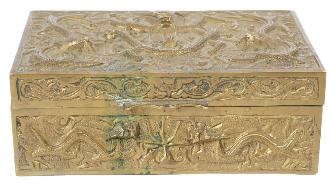 1920s High Relief Chinese Brass Cigarette Box: High relief brass cigarette box, wood lined. Depicts dragons on lid and all side panels. Bottom signed China. Measures 5-3/8" wide.