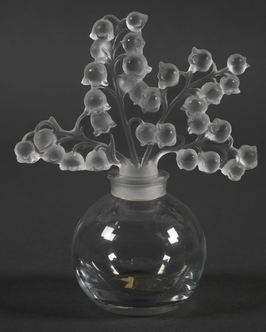 LALIQUE Perfume Bottle, Lilly of the Valley: Crystal perfume bottle in Lilly of the Valley pattern by Lalique, France with original label under base. Measures 5" tall.
