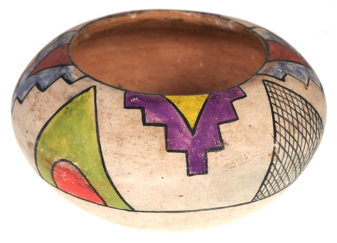 NATIVE AMERICAN Pottery Bowl, Polychrome: Antique Southwestern Indian terra cotta bowl with painted geometric shapes in bright colors on a white background. Signed under base. Measures 5-1/2" diameter and 3" tall.