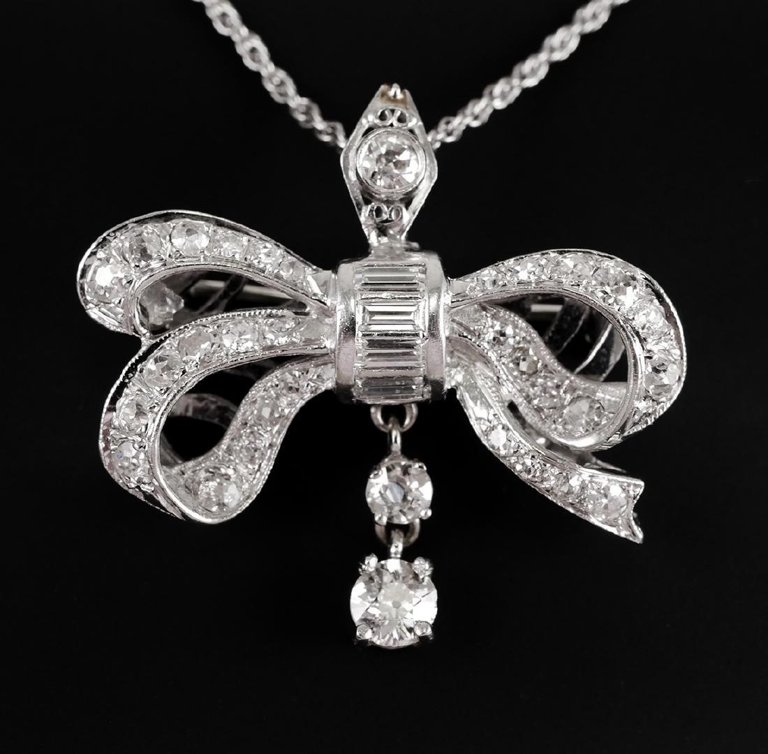 14k White Gold Diamonds Bow Pendant or Pin: Vintage Edwardian diamond covered bow pendant in 14k white gold with chain. Weighs 7.1 grams. Mixed cuts, including mine cut. Measures a little over 1" wide. Pin back, can be worn as a brooch.