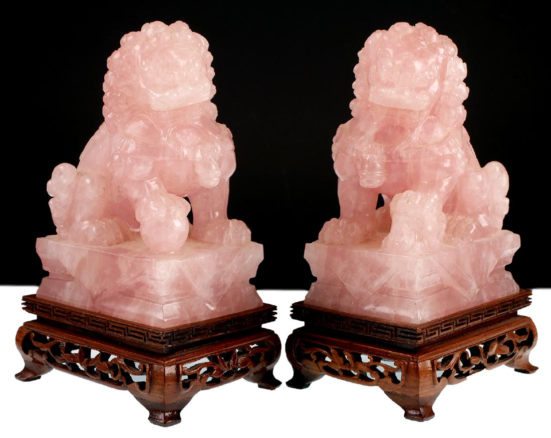 Pair of Foo Lions in Rose Quartz: Pair of Foo Lions/Dogs hand carved from pink quartz. Each with wooden stand and measuring 4 3/4" tall.