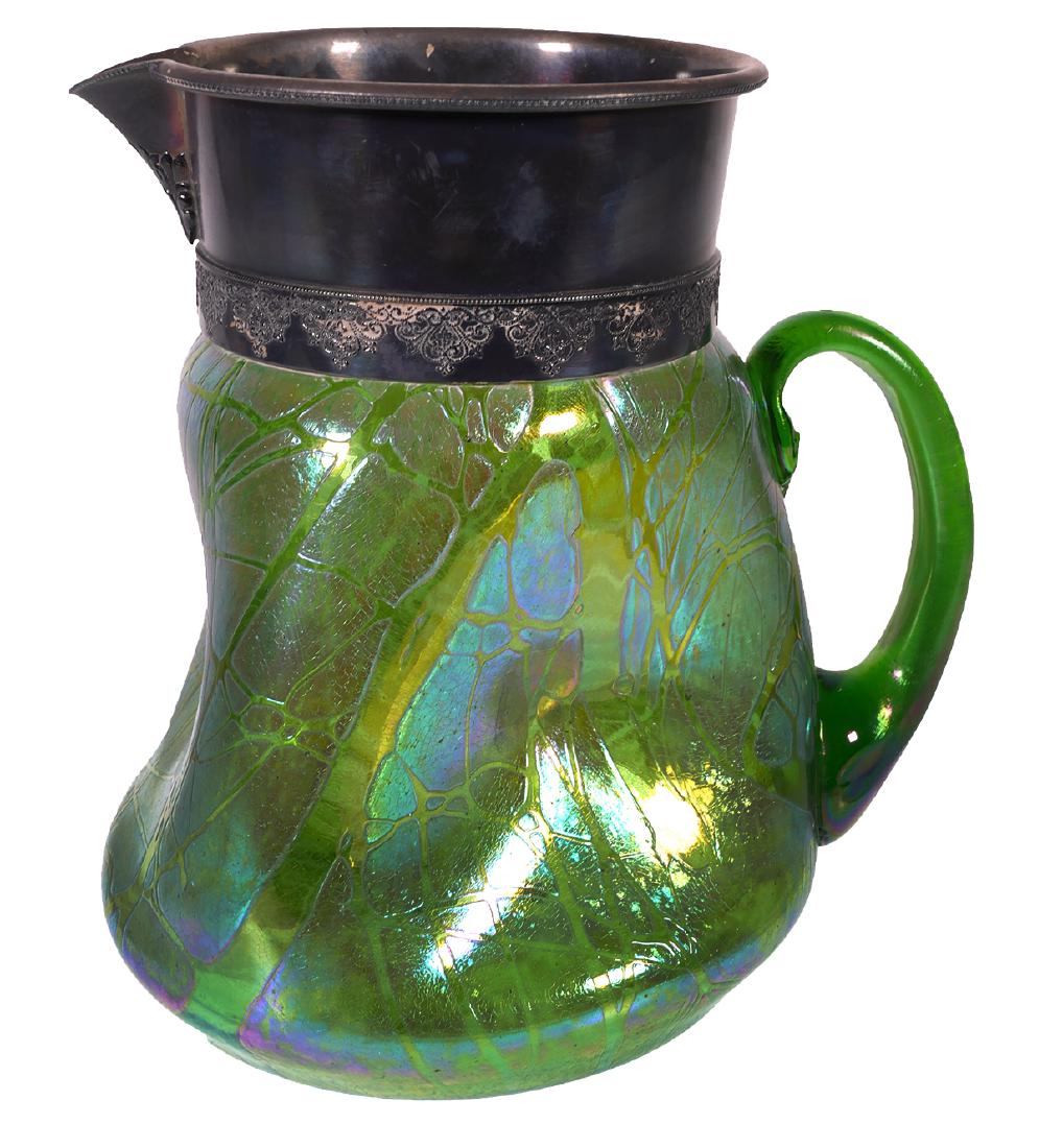 LOETZ Iridescent Art Glass Water Pitcher: Large silverplate rimmed antique water pitcher with iridescent glass body, in the style of Loetz. Pinched sides. Measures 9" high and about 7" in diameter. Tarnished silver. No damage on glass. Unsign