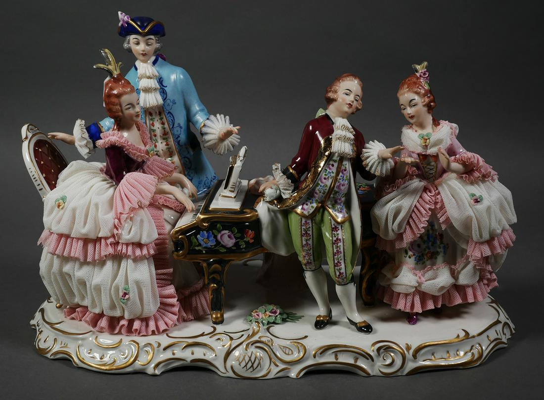 CAPODIMONTE Figurine Woman Playing Piano: Capodimonte porcelain figural group of a woman playing the piano. N with crown mark to underside. Some lace loss to dresses & cuffs on figure with blue coat. No cracks or repairs. Measures 9 1/8" tall
