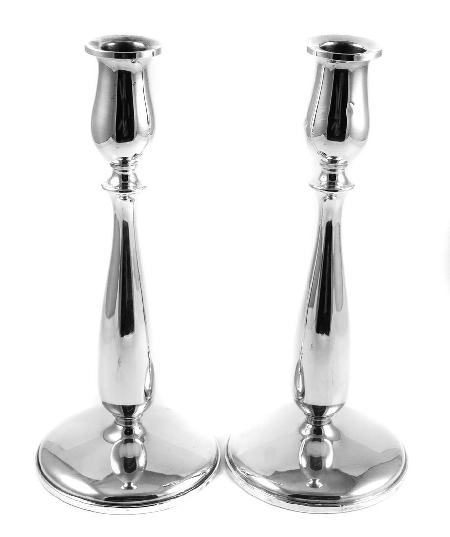 CARTIER Sterling Silver Candlesticks: Weighted sterling silver candle stick holders by Cartier. Each measures about 9-1/4" high. A few bumps to edge of base and a bump on the side of one cup. Overall nice condition. No monograms or engrav