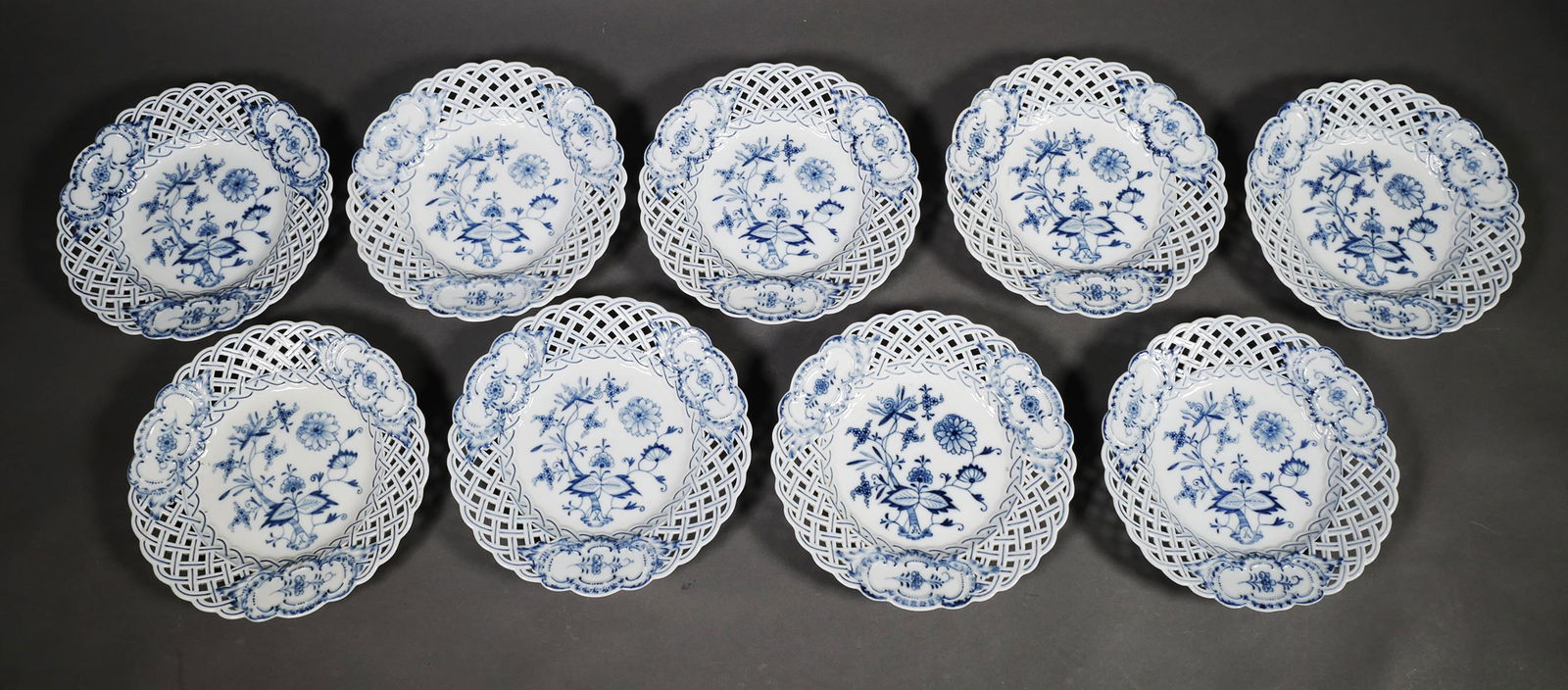 (9) Meissen Blue Onion Pierced Rim Plates: Group of 9 Meissen Blue Onion pattern reticulated openwork plates. Crossed swords mark under bases. Circa 19th century. Excellent condition with no chips, cracks or damage. Each measures 7 7/8".