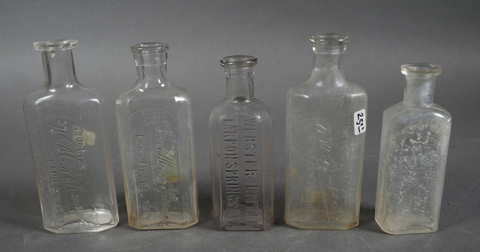 Antique Florida Glass Medicine Bottles (5): Five clear glass antique Florida medicine bottles: Fort Meade Pharmacy, Ft. Meade Fl, no damage; Webster Little, Tarpon Springs no damage; St. George Pharmacy, St. Augustine small lip fleabite, cloudy