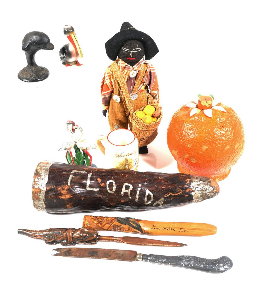 FLORIDA Vintage Souvenir Items (9): Nine vintage souvenir items from around Florida, including an older Black memorabilia orange picker doll, cast metal flamingos and dolphin, an orange blossom honey container, etc.
