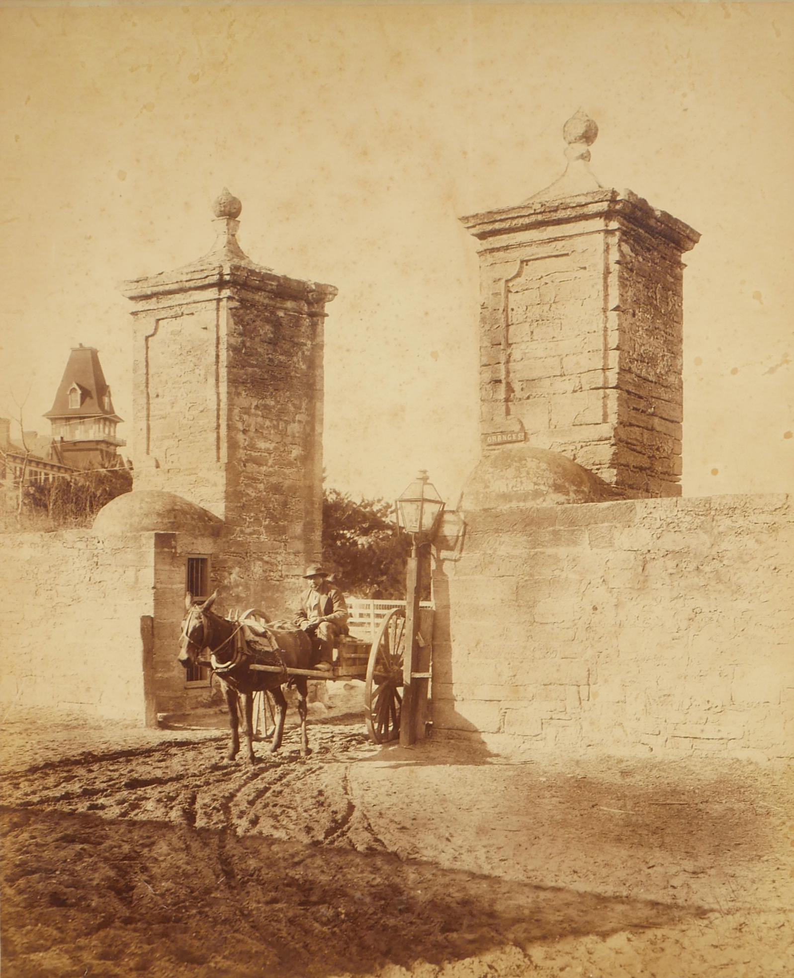 GEORGE BARKER, St. Augustine Photograph, Massive: Extremely large antique mounted photograph of the city gates at St. Augustine. Attribution for George Barker at lower left and verso. Image size measures 16 1/2" x 21". Framed to 21" x 25". Excellent 