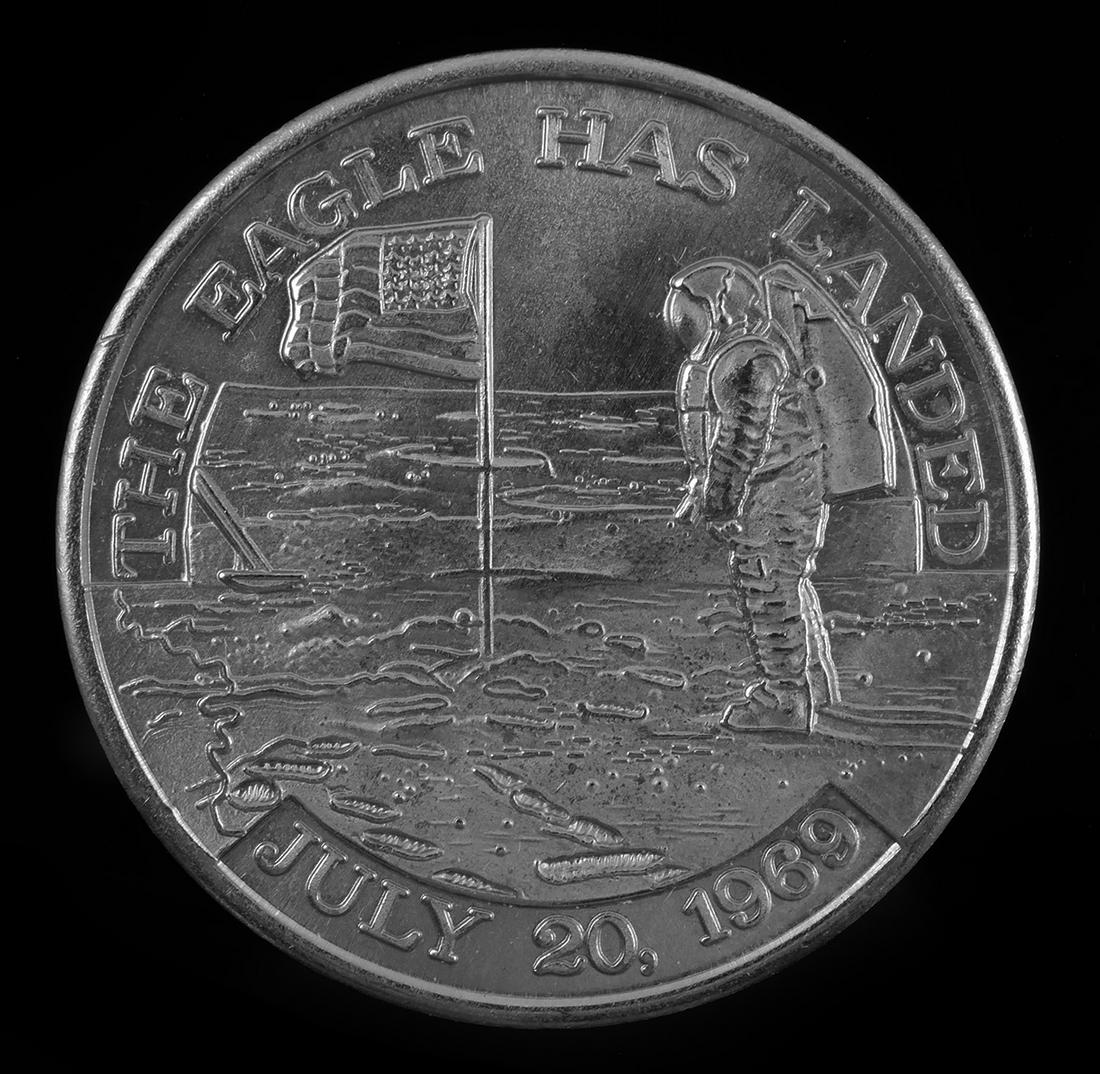 APOLLO 11 Coin SPACE FLOWN: Flight Awareness Medallion commemorating the Apollo 11 mission from the collection of a NASA employee and associate of Wernher von Braun. Well-struck on both sides. One side reads "The Eagle Has Lande