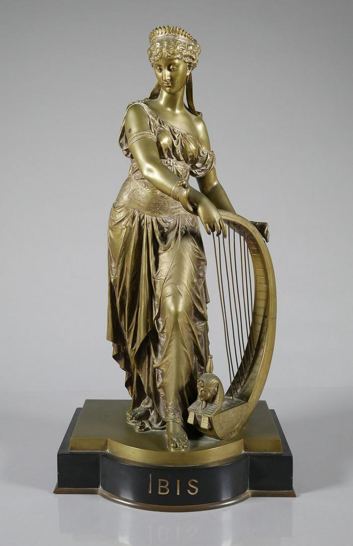 Egyptian Revival IBIS Statue: Cast metal statue of a woman with a harp, in Egyptian revival style. Titled "IBIS" on the base, similar subject to "The Singer" by Edward Onslow Ford. Very good condition with one harp string missing.