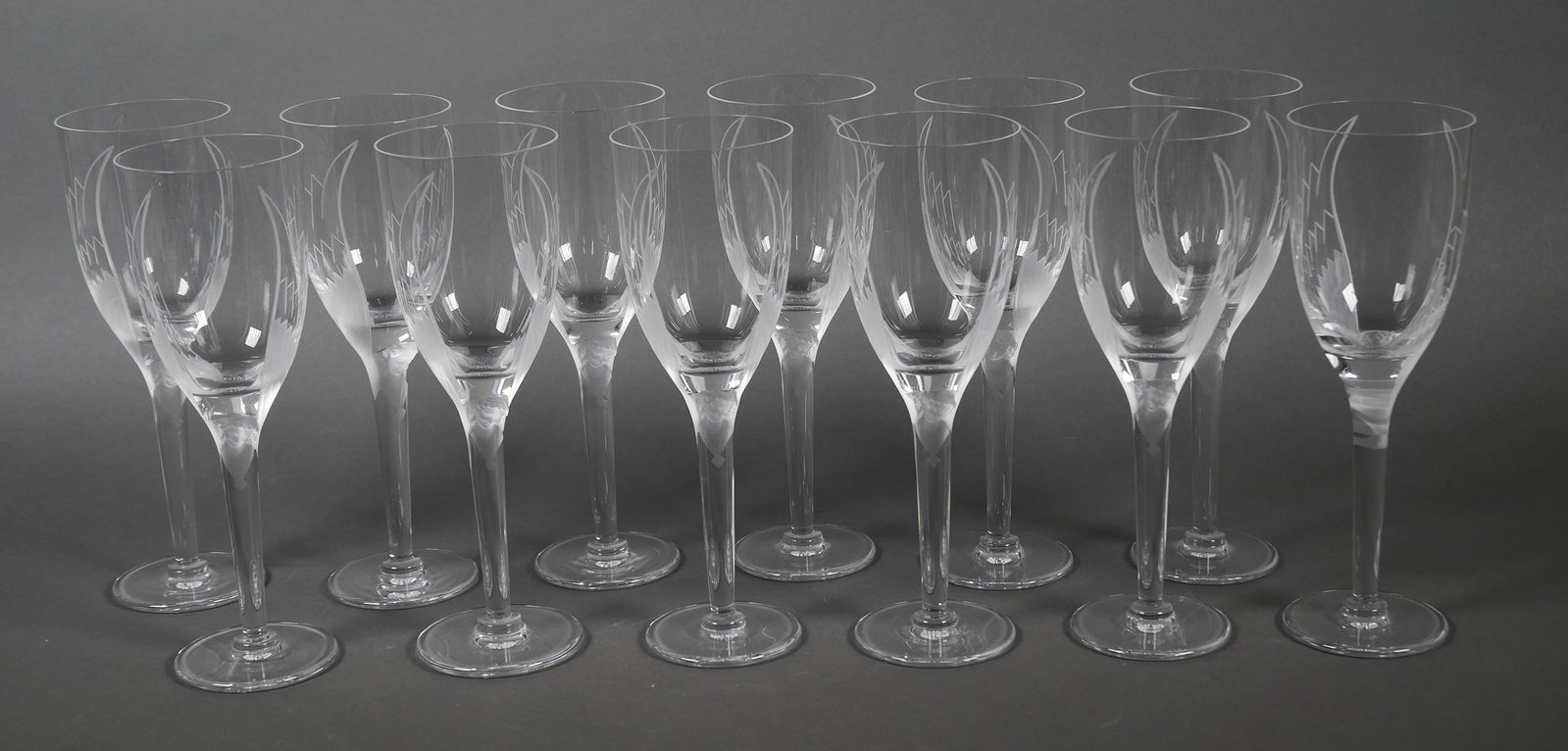 (12) LALIQUE FRANCE Crystal ANGEL Champagne Flute: Set of 12 Angel clear and frosted crystal art glass champagne flute or wine glasses. Hand-etched unfurled angel wings embrace the bowls of these flutes before tapering downward to the ethereal, three-