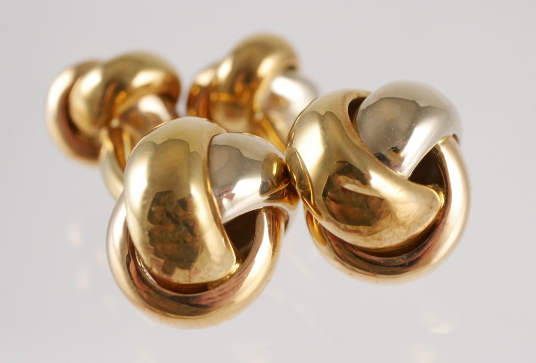 Pair CARTIER 18K Tri Color Gold Trinity Cufflinks: Pair of 18K tri-color gold, "Trinity" double knot cuff links by Cartier. The tops measure 14 mm and the backs measure 10.74 mm in diameter. Each has a curved bar connector. Marked Cartier 984695, over
