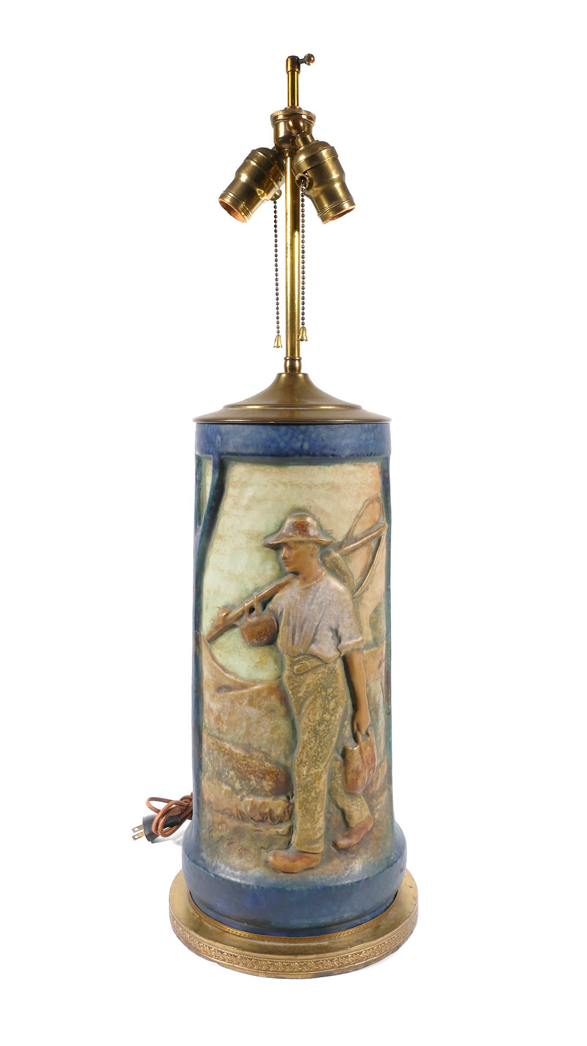 ART NOUVEAU Amphora Austria Art Pottery Lamp: Art Nouveau art pottery table lamp with farmhouse and farmer with sickle or scythe. Pottery measures approx. 16 1/4" tall, overall lamp measures 29". Two bulb lamp is in working condition. Exterior ha