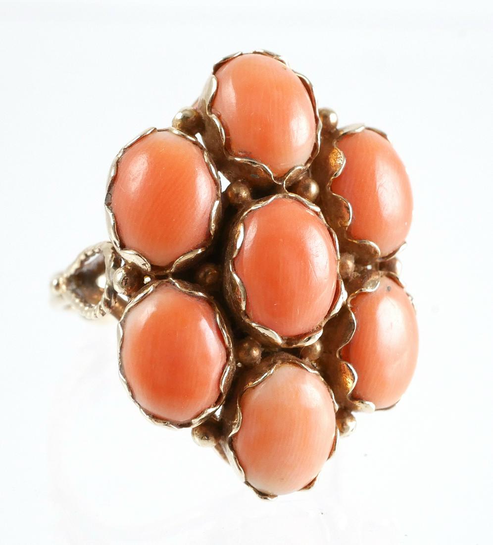 14K Yellow Gold Coral Cabochon Cocktail Ring: 7 pink coral oval cabochons set in a 14K yellow gold. Cocktail ring has a vintage look with a split band design. Ring size is 6 3/4. Total weight is 6.7 grams. Ring has age appropriate wear with no cr