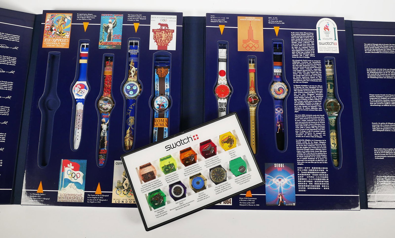 SWATCH WATCH Parts Display & Olympics Set: Swatch display and Olympics set (missing one watch). Provenance: From the surviving family of the "King of Swatch," Daniel J. Komar, from his private collection. After his passing in 2013, Komar's mas