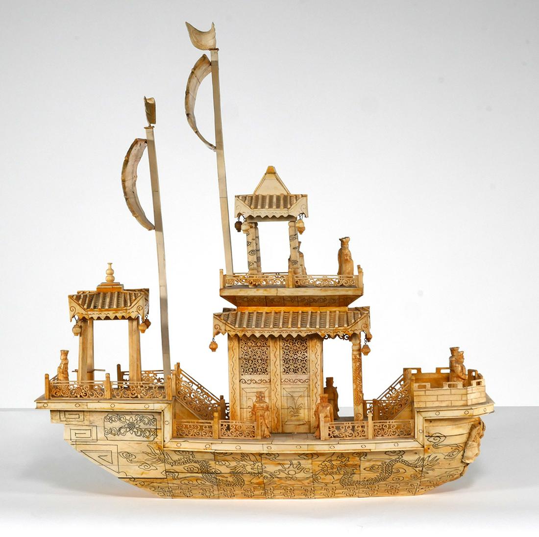 Chinese Bone Carved Junk Model: Chinese Junk features a full sail above pagodas and balcony with figures. There is a total of 9 figures on board. Grotesque mask on bow. Sailing ship measures approx. 24" long x 26" tall x 8" wide, ap