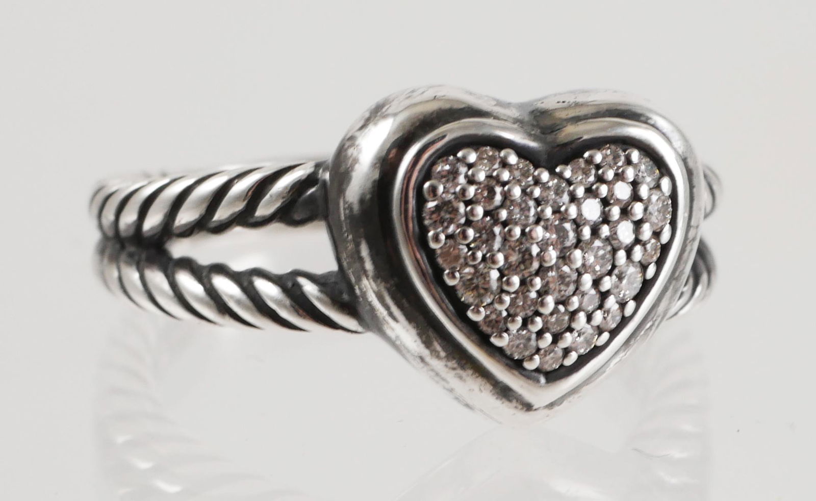David Yurman Petite Pave Diamond Heart Ring: Delicate heart design with dramatic pave' set diamonds in sterling silver. Approx. .06 cttw. Ring is marked DY 925, size 7 1/2, 6.2 grams total weight. See photos for more details on condition.