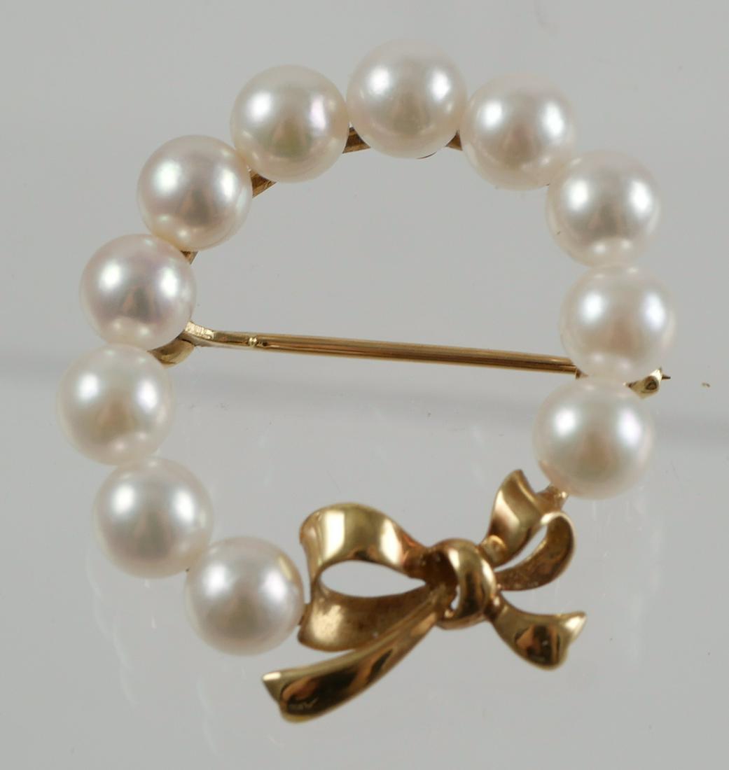 14K Mikimoto Wreath Bowtie Pearl Brooch Pin: Set in 14K yellow gold with fine luster pearls and bowtie design. Mikimoto hallmark M with shield and 585 on back of brooch. Brooch measures 1 1/8" in diameter, 5.0 grams total weight. Good condition 