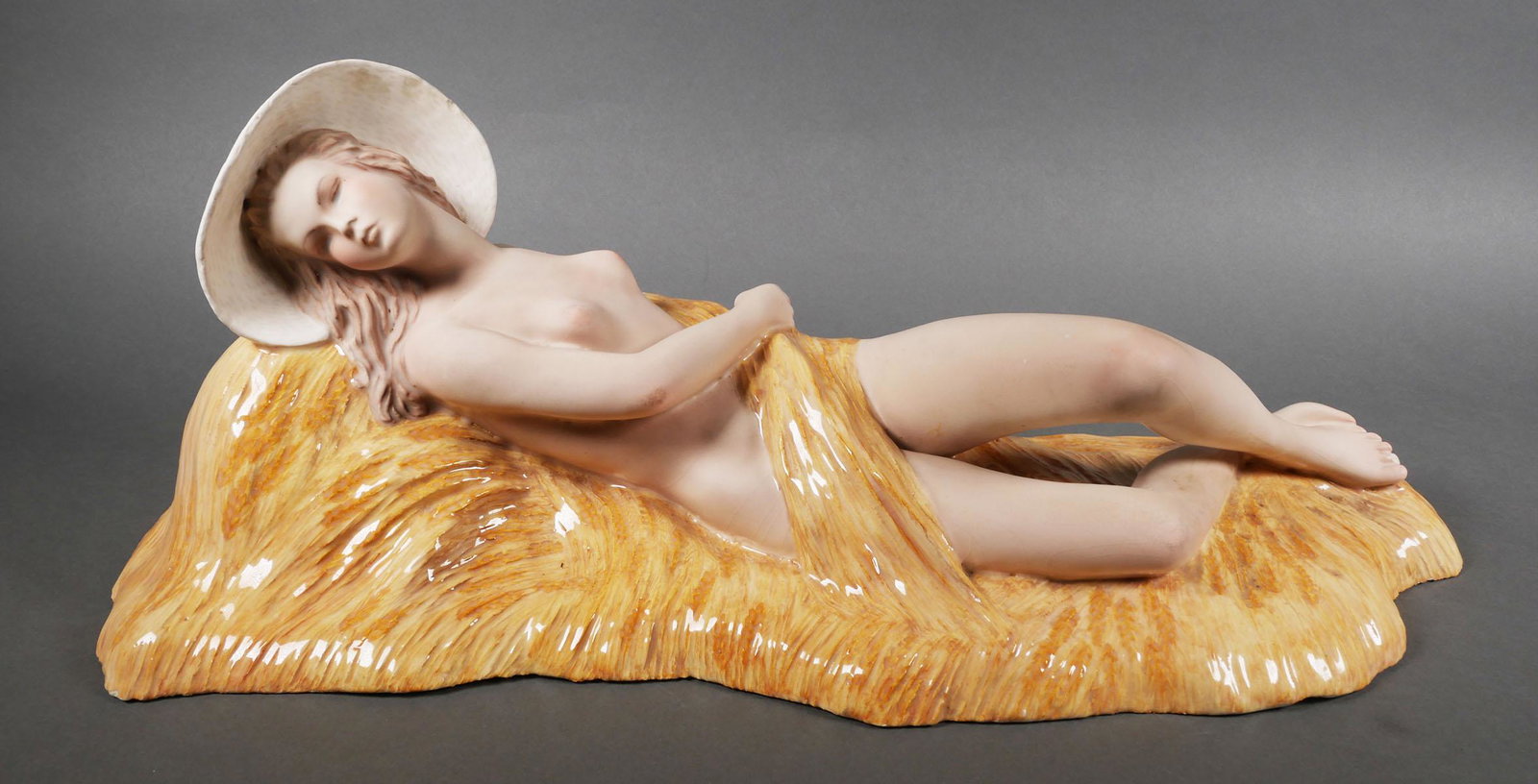 Le Bertetti Porcelain Nude Sculpture: Le Bertetti "La Mietitrice" nude porcelain woman lying down in a bed of wheat. Signed Le Bertetti TORINO - MADE IN ITALY "La Mietitrice" No 401, R, 1060 S. Figurine measures approx. 23" long x 8 3/4"
