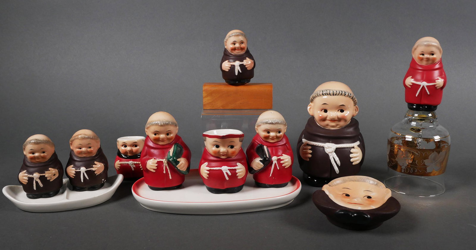 Collection Goebel Friar Tuck Monk Figurines: Collection of 10 Goebel Friar and Cardinal Tuck monk figures including; Cardinal creamer, spoon rest, salt and pepper with tray, pretzel holder, creamer set. Largest monk (bell) measures approx. 6 1/2