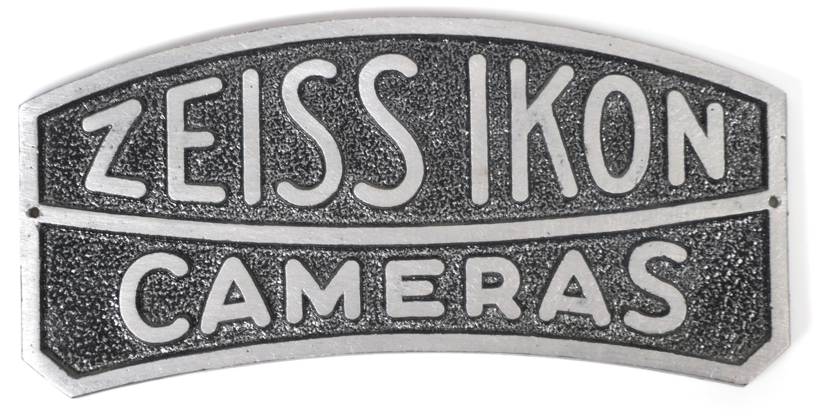 Vintage Zeiss Ikon Cameras Dealer Metal Sign: Zeiss Ikon Cameras plaque style metal dealer advertising sign. Logo sign measures 7 5/16" x 3 5/8. Mounting holes on each end. No cracks or paint loss. Please see our other auction lots for more vinta