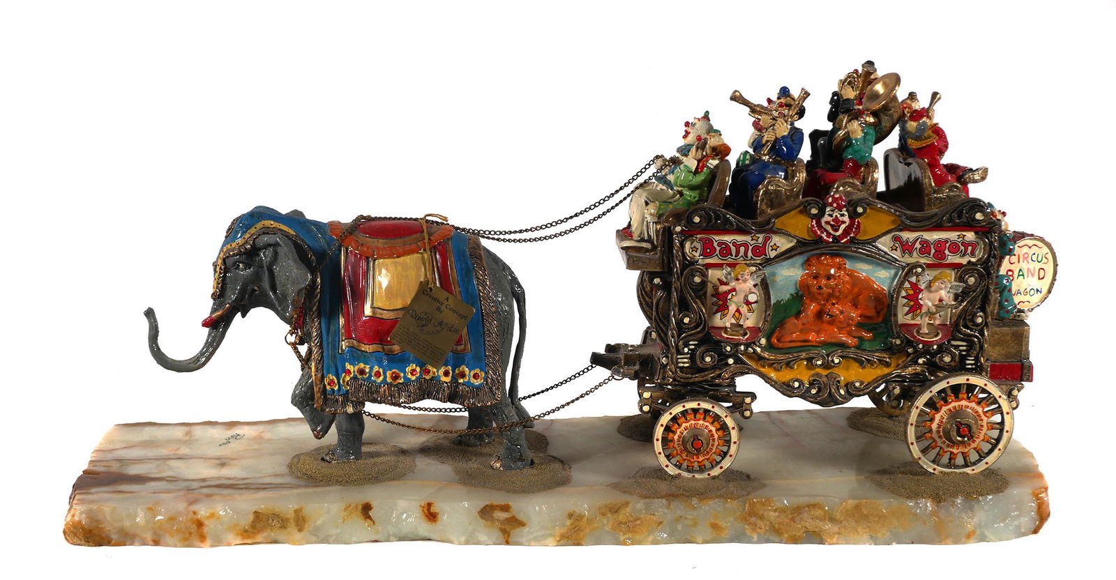 Ron Lee Circus Band Wagon Sculpture Signed: RON LEE, 1947-2017, "BAND WAGON" Sculpture, 1985. Signed and dated on the stone base. Sculpture measures approx. 12" x 26", approx. 34 lbs. Some areas of repairs, minor paint loss and gold beading los
