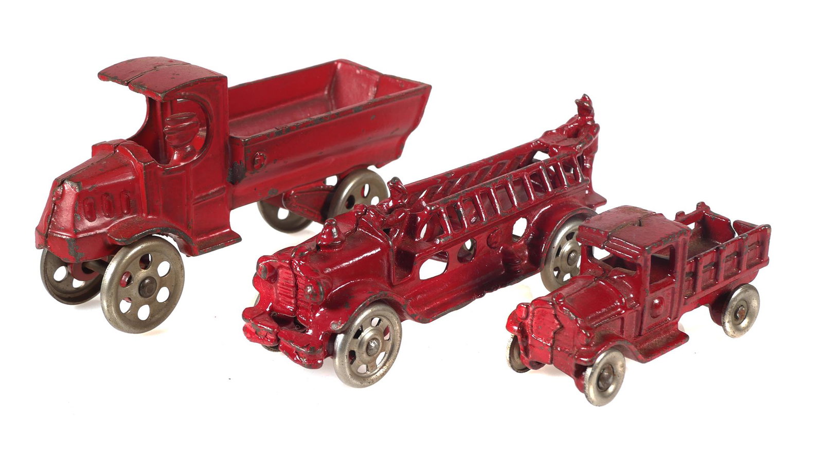 (3) Antique Red Cast Iron Toy Trucks: Largest dump truck measures 5 1/4" x 2 3/4", fire truck or ladder truck measures 5 1/4" long x 2", stake truck measures 3 1/4" long x 1 1/2". Possibly made by Kenton, Hubley, AC Williams or Arcade.
