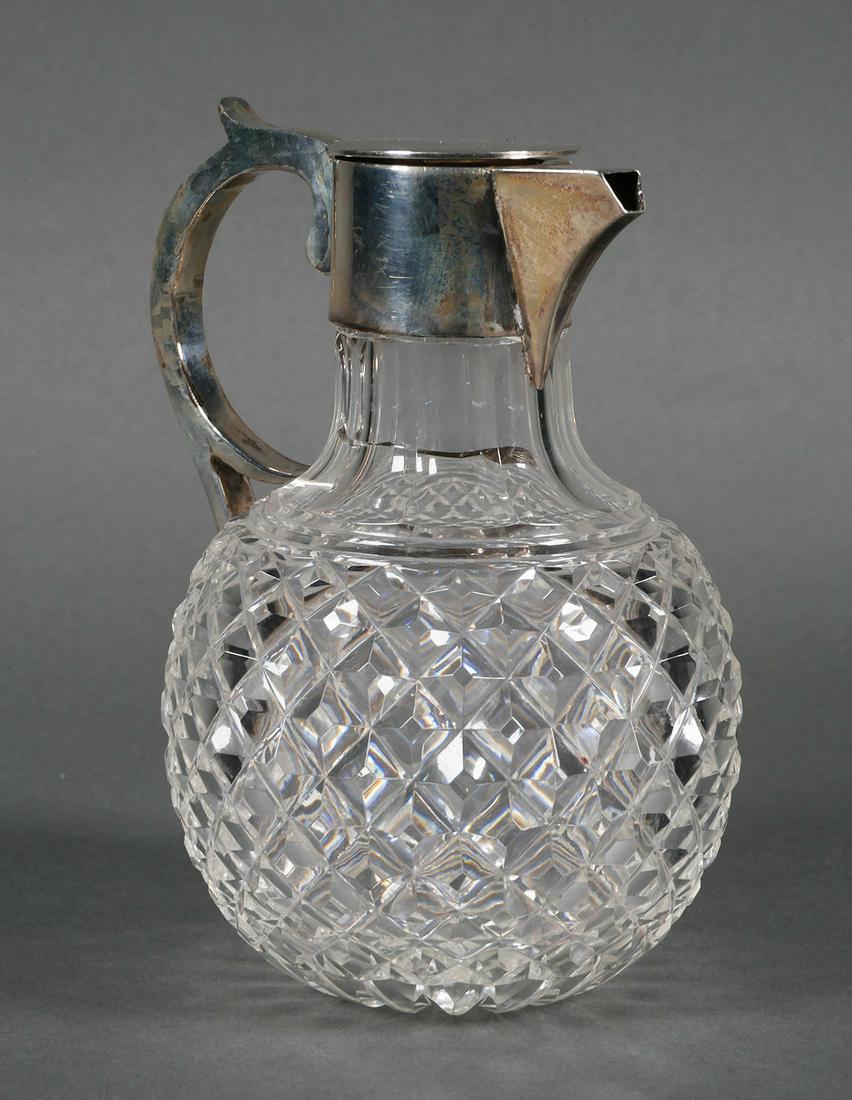 English Sterling & Cut Glass Syrup Pitcher: Sterling silver lid is hallmarked G&S Co. Ltd., Goldsmiths and Silversmiths Company. Pitcher measures approx. 7 1/ 2" tall x 6" wide. Crack to neck.