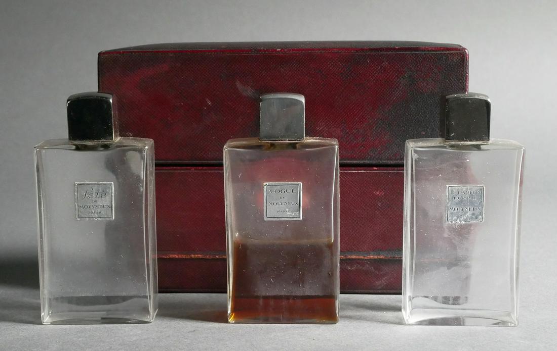 Three Molyneux Perfume Bottles in Case: Leather box of three Molyneux crystal perfume bottles, each bottle measures 3 ¾” (h) x 1 7/8” (w) x 1” (d), parfum, French art glass.